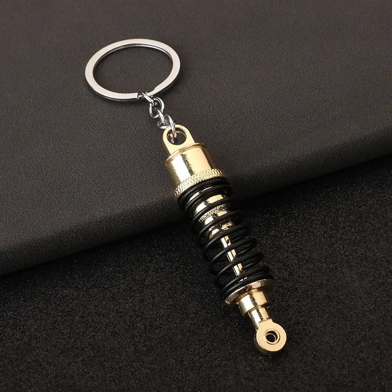 Car Shock Absorber Keychain ميدالية على شكل جامبينات مساعدات سيارة في علبة وتغليف