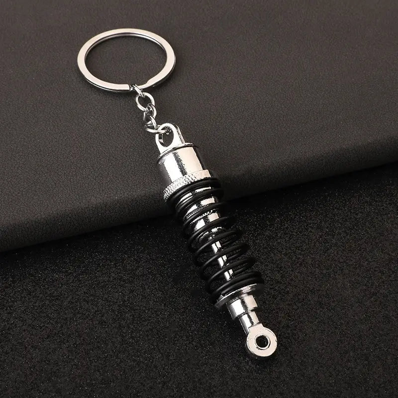 Car Shock Absorber Keychain ميدالية على شكل جامبينات مساعدات سيارة في علبة وتغليف